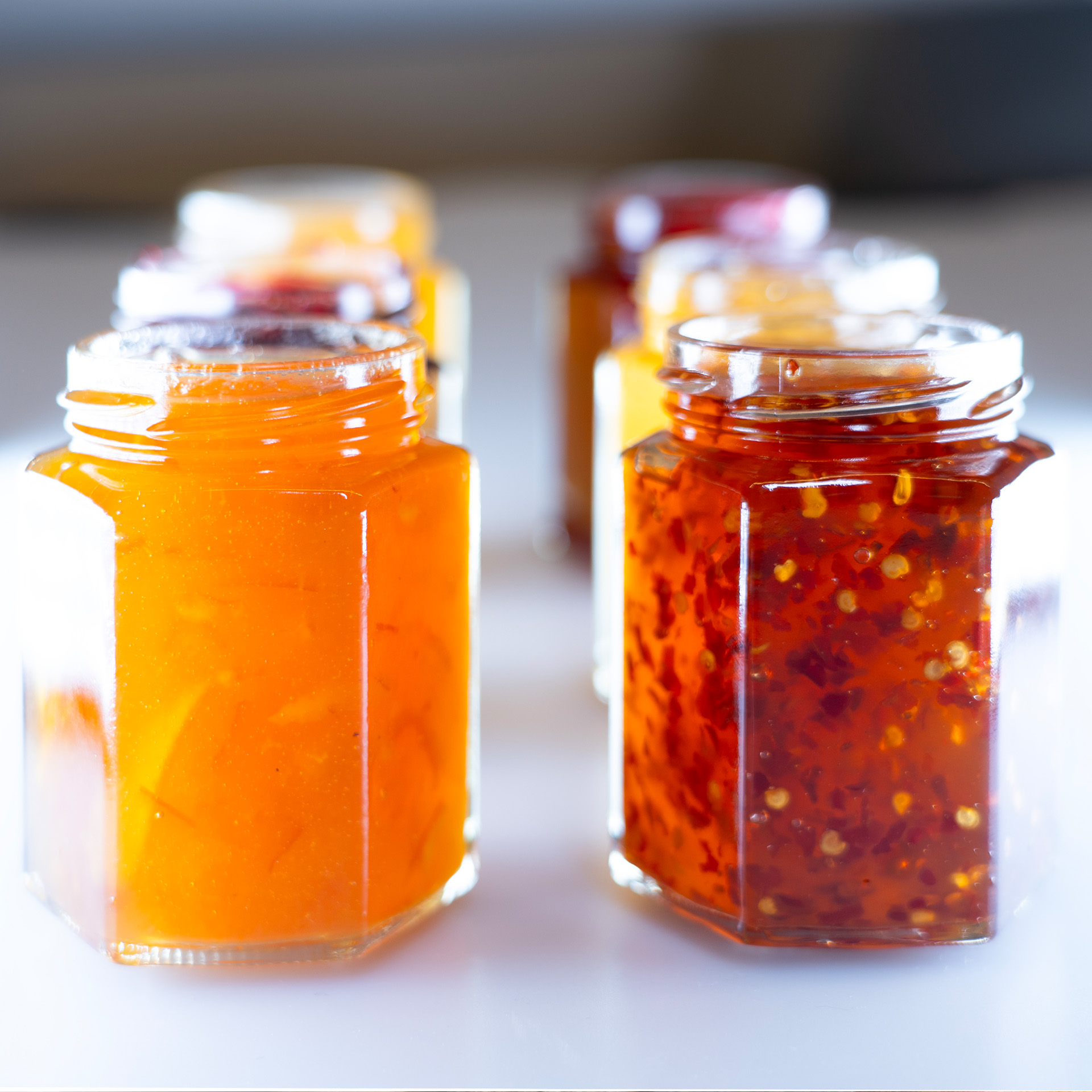 Zwei Reihen Marmeladengläser nebeneinander, perspektivisch fotografiert, als Symbol für individuelle Private-Label-Kompositionen.